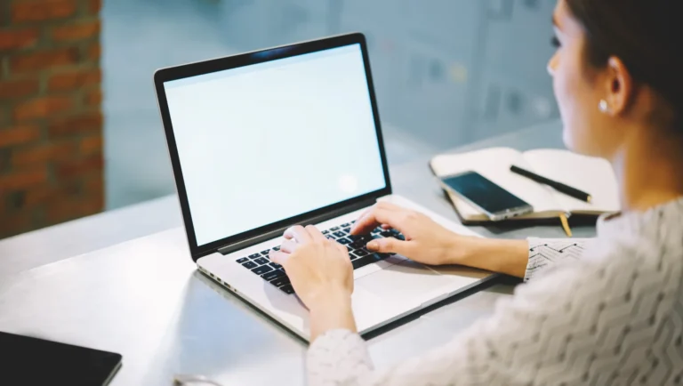 A woman submitting an article as a guest through her laptop in an office.